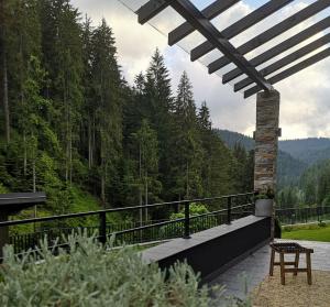 ein Balkon mit Tisch und Blick auf einen Wald in der Unterkunft GORA - Вила Villa for 22 Guests, Пампорово, Rhodope Mountains in Progled