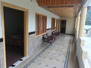 Zimmer mit einem Flur mit Stühlen und einem Bett in der Unterkunft ViveGee Cottage Khanipur Ayubia in Ayubia