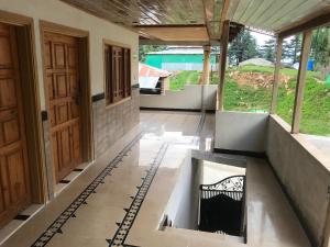ein leeres Zimmer mit einer Tür und einem Boden in der Unterkunft ViveGee Cottage Khanipur Ayubia in Ayubia