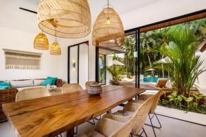 烏布的住宿－Villa Crystal Lagoon by Bali Superhost，一间带木桌和椅子的用餐室