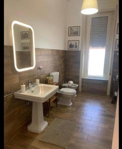 a bathroom with a sink and a toilet and a mirror at "Sabbinirica" in Syracuse