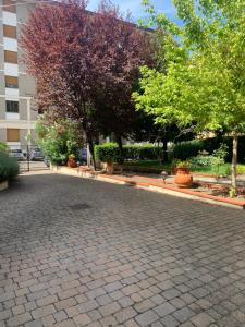 a brick parking lot with trees and a building at Home53 in Arezzo