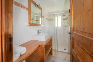 y baño con lavabo y ducha. en Village de gîtes Les Chalets de l'Aubrac en Aumont-Aubrac