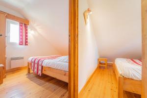 a bedroom with two beds and a mirror at Village de gîtes Les Chalets de l'Aubrac in Aumont-Aubrac +27 photos