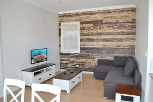 a living room with a couch and a brick wall at Rockleigh in South West Rocks