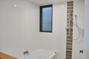 a white bathroom with a shower and a window at Rockleigh - Bring your own linen. in South West Rocks +10 photos