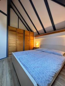 a bedroom with a large bed with wooden cabinets at Ferienhaus Odenwald in Michelstadt
