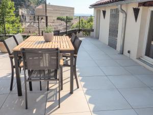 uma mesa de madeira e cadeiras num pátio em Le Rooftop - Vue incroyable sur le Théatre Antique em Orange