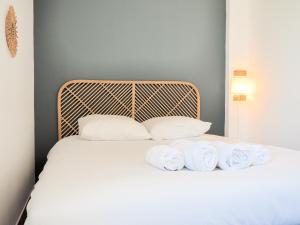 uma cama com almofadas brancas e toalhas em Le Rooftop - Vue incroyable sur le Théatre Antique em Orange