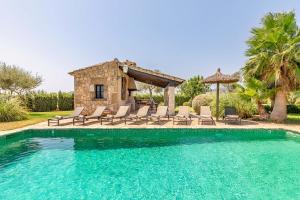 a villa with a pool and chairs and a house at Villa Can Paroya in Alcudia