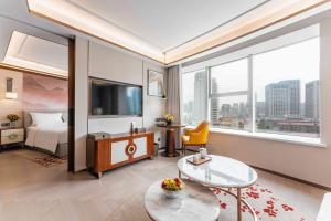 a hotel room with a bed and a large window at Yun-Zen Century Hotel in Shijiazhuang