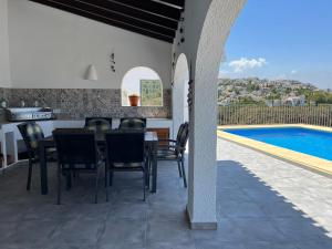 a patio with a table and chairs next to a swimming pool at El Valle Verde in Monte Pego