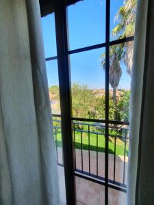 une fenêtre avec vue sur un palmier dans l'établissement POSADA LOS PEDREGALES, à El Granado