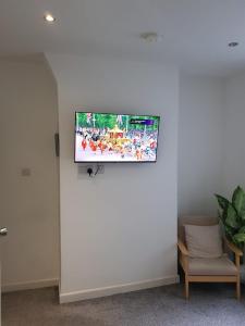 TV de pantalla plana colgada en una pared blanca en Tropicana House en Barnsley