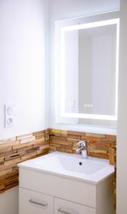 La salle de bains est pourvue d'un lavabo blanc et d'un miroir. dans l'établissement Monti-love, à Montivilliers