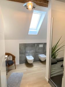 uma casa de banho com uma clarabóia, um WC e um lavatório. em Gästehaus Rheinromantik em Bacharach