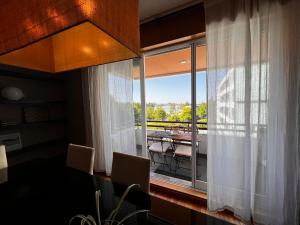 Cette chambre dispose d'une grande fenêtre avec une table et d'un balcon. dans l'établissement Porto River View Apartment, à Porto