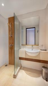 a bathroom with a sink and a glass shower at Prima In Hotel Malioboro in Yogyakarta