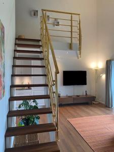 escalera de caracol en una sala de estar con TV en Søbyen en Skanderborg