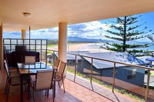 a balcony with a table and chairs and a tree at Northpoint Apartment 5 in South West Rocks