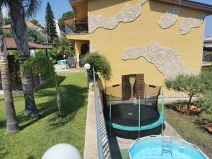 einem Pool vor einem Haus mit einer Wasserrutsche in der Unterkunft Casa Maremonti vicino Cefalu in Campofelice di Roccella