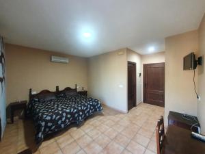 una camera con un letto nell'angolo di una stanza di POSADA LOS PEDREGALES a El Granado