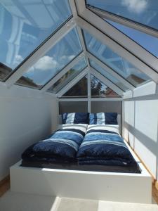 Bett in einem Zimmer mit einem großen Fenster in der Unterkunft Ferienwohnung Freyas Walderlebnis in Stromberg