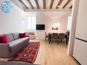 ein Wohnzimmer mit einem Sofa und einem Tisch in der Unterkunft Cavana 5 Tirabora Short Rent in Triest