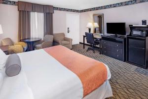 a hotel room with a bed and a desk at Howard Johnson by Wyndham Lenox in Lenox