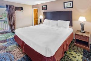 um quarto de hotel com uma cama grande e uma janela em Travelodge by Wyndham Great Barrington Berkshires em Great Barrington