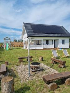 a house with a solar roof and a playground at Fuledzki Biały Domek - Mazury, Jacuzzi, Sauna, Giżycko in Fuleda
