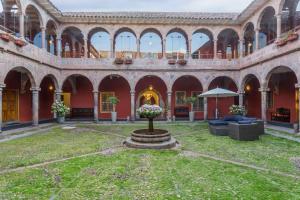 einen Innenhof in einem alten Gebäude mit einem Brunnen in der Unterkunft Costa del Sol Wyndham Cusco in Cusco