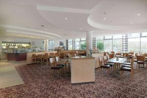 um restaurante com mesas e cadeiras e um bar em Ramada by Wyndham Dresden em Dresden