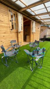a group of chairs sitting on the grass in front of a house at Bombay Camping Company, Pawna Lake Lonavala in Lonavala