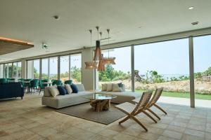 a living room with a couch and a table and chairs at Watermark Hotel & Resorts Okinawa Miyakojima in Miyako Island
