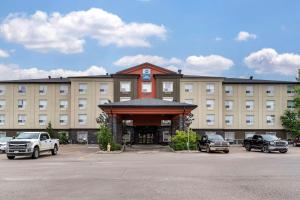 een hotel met auto's geparkeerd op een parkeerplaats bij Best Western Bonnyville Inn & Suites in Bonnyville