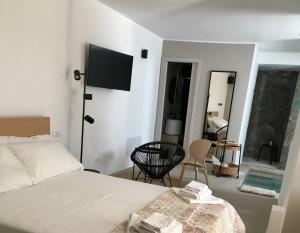 um quarto com uma cama e uma televisão na parede em QUIRICO GUEST HOUSE em Locorotondo