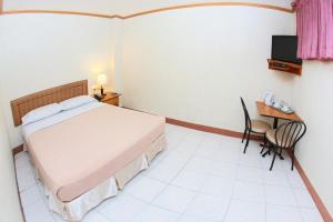 1 dormitorio con 1 cama, 1 mesa y 1 silla en Elegant Circle Inn, en Cebú