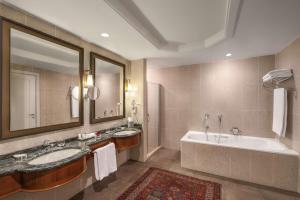 a bathroom with two sinks and a tub and a large mirror at Hyatt Regency Baku in Baku