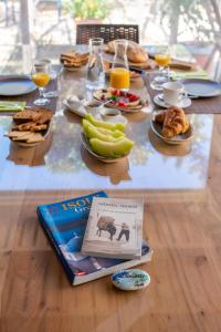 a table with breakfast foods and a book on it at La Casa di Dolly in Galanado
