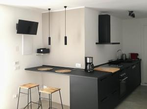 a kitchen with a black counter and two stools at QUIRICO GUEST HOUSE in Locorotondo