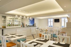 a restaurant with white tables and chairs and a bar at Dolce CampoReal Lisboa in Turcifal