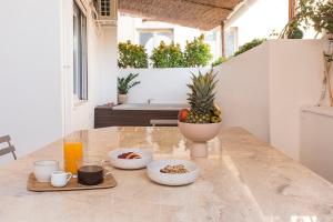 a table with a bowl of fruit and drinks on it at Luxury Apartment with Jacuzzi Close to Acropolis - Living Stone Zircon in Athens