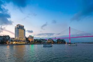 a bridge over a river with boats in the water at Wyndham Legend Halong in Ha Long