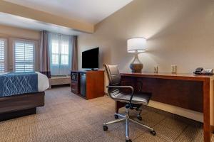 a hotel room with a desk and a bed and a chair at Comfort Inn & Suites Ukiah Mendocino County in Ukiah