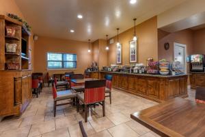 ユカイアにあるComfort Inn & Suites Ukiah Mendocino Countyのバー、テーブル、椅子が備わるレストラン