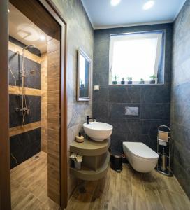 uma casa de banho com um lavatório, um WC e uma janela. em MARSY em Sandanski