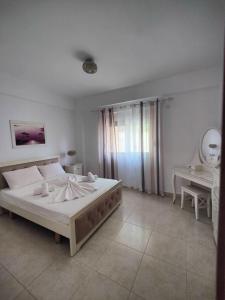 a white bedroom with a large bed and a desk at Amazing View Apartments at Kroi i Gjine, Piqeras in Piqeras