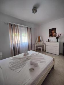 Un dormitorio con una cama blanca con toallas. en Amazing View Apartments at Kroi i Gjine, Piqeras en Piqeras