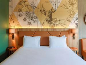 1 cama con 2 almohadas blancas en una habitación en Mercure Han-sur-Lesse, en Han-sur-Lesse